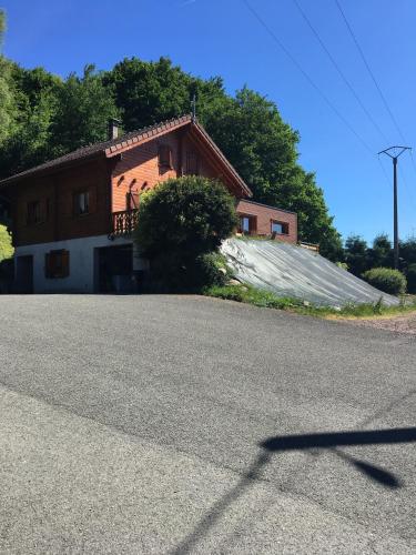 a house with a large driveway in front of it at chalet vosgien in Le Ménil