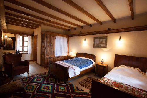 a bedroom with two beds and a chair in a room at Hoyran Wedre Country Houses in Davazlar