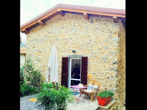 una casa de piedra con mesa y sillas al aire libre en Belvilla by OYO Holiday home with garden en Pian dʼOrsina