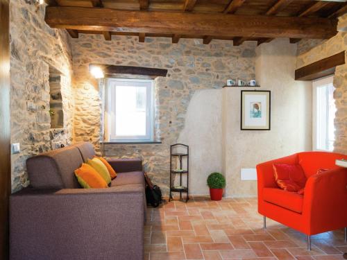 uma sala de estar com um sofá e uma cadeira vermelha em Belvilla by OYO Holiday home with garden em Pian dʼOrsina