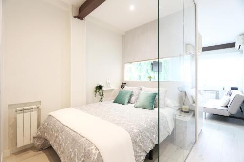 een witte slaapkamer met een bed en een glazen wand bij Urbantec Realty - Núñez de Balboa - Castellana in Madrid
