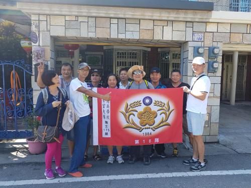 a group of people standing in front of a building holding a flag at Fire B&B in Chishang