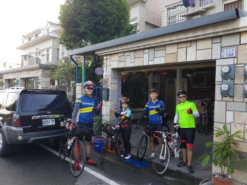 a group of people standing outside a building with their bikes at Fire B&B in Chishang