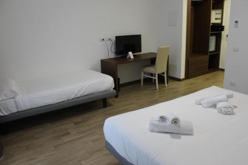 a hotel room with two beds and a desk at Hotel Bocciolo in Orta San Giulio