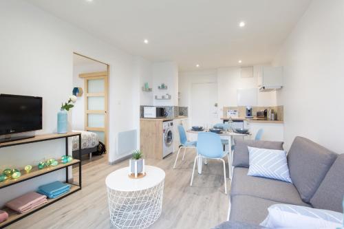 un salon avec un canapé et une table et une cuisine dans l'établissement PARENTHESE - Le Marqui, à Lourdes