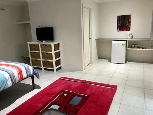 uma sala de estar com um tapete vermelho no chão em Little Shangri-La em Busselton