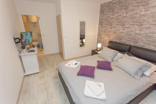 een groot bed in een kamer met een bakstenen muur bij Apartments Villa Sol in Ston