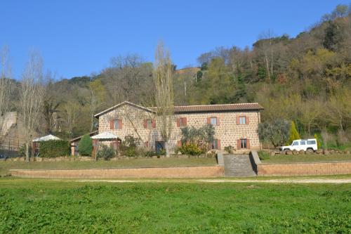 a large brick house with a truck parked in front of it at Agriturismo Le Forre del Treja in Civita Castellana