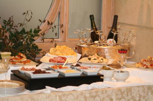 a table with several plates of food and bottles of wine at Hotel Capitol Milano in Milan