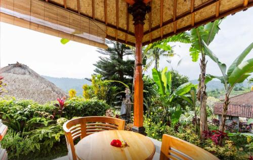 a wooden table and chairs on a patio at Lila Stana - Sidemen Homestay in Sidemen