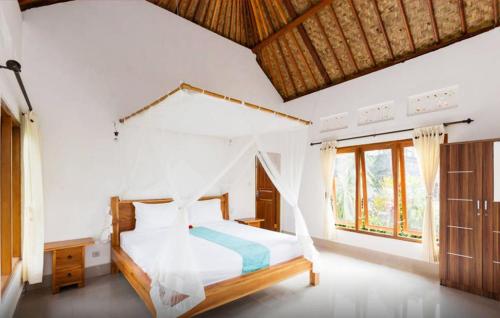 a bedroom with a bed with a mosquito net at Lila Stana - Sidemen Homestay in Sidemen