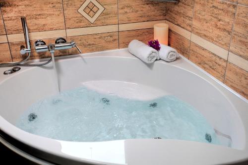 a bath tub filled with water with towels in it at Anemonisia Deluxe Apartments in Skiros