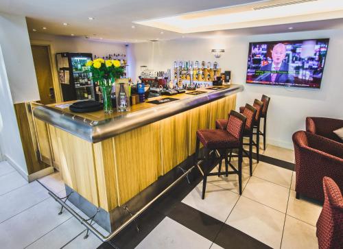 a bar in a restaurant with chairs and flowers at Mannin Hotel in Douglas