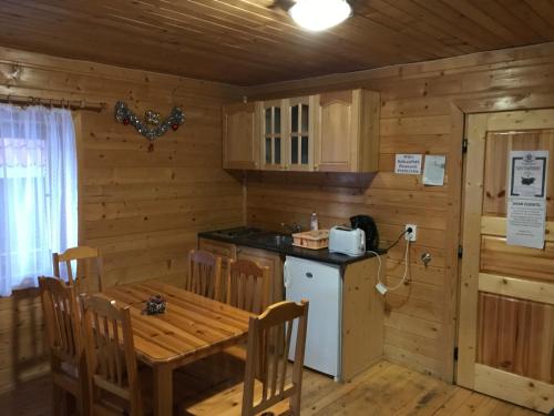 eine Küche mit einem Tisch, einem Herd und einem Kühlschrank in der Unterkunft Chalet Sofia in Borowez