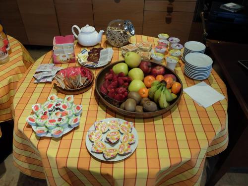 a table with a bunch of fruits and plates on it at B&B Eldorado in Sommacampagna