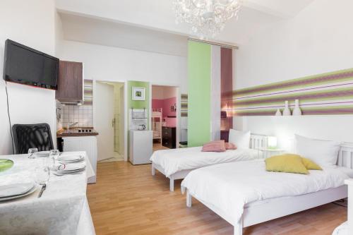 ベルリンにあるModernes 2-Zimmer-Apartment in Kollwitzplatz-Näheのベッド2台、ダイニングテーブルが備わる広い客室です。