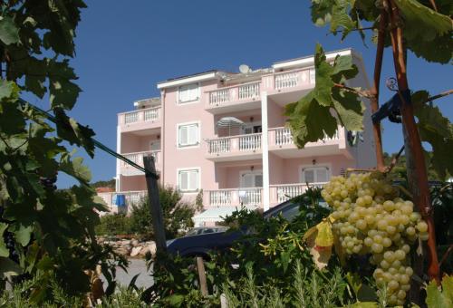 Um edifício com um monte de uvas à frente. em Guesthouse Villa Ljubica em Soline