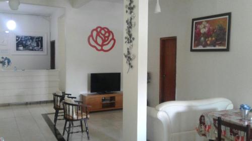 ein Wohnzimmer mit einem TV und ein Wohnzimmer mit einem Tisch in der Unterkunft Hotel HB in Planaltina