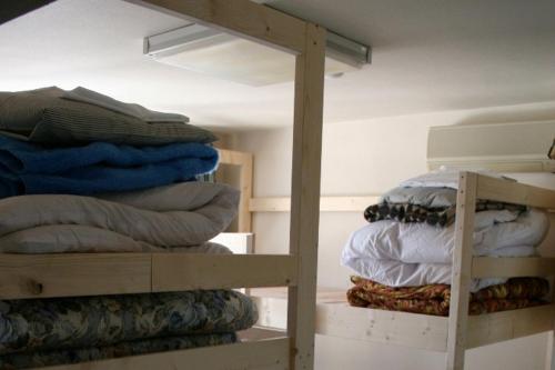 a room with a bunk bed and a pile of pillows at Travellersdou Kirinya in Uji