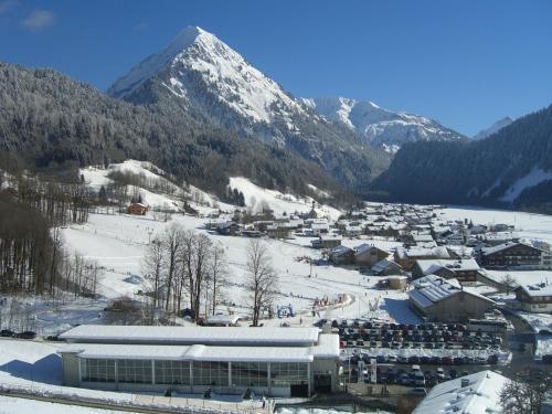 a small town in the snow with a mountain at Pension Haus Romy in Schoppernau