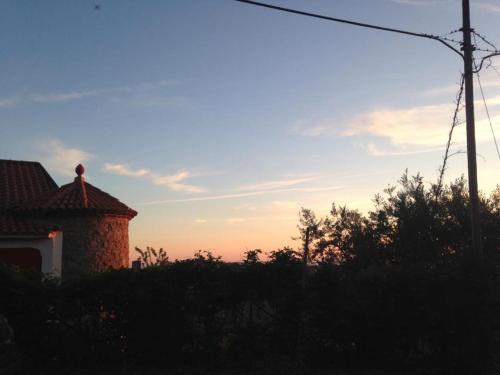 a house with the sunset in the background at Antica Residenza Voso in Laureana Cilento