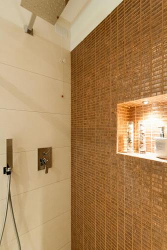 a bathroom with a shower with a tiled wall at San Marco Luxury apartament with terraces in Venice
