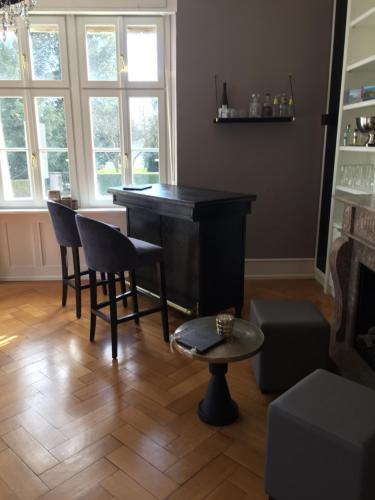 a bar in a living room with chairs and a table at Hotel Garni Villa Rosengarten in Überlingen