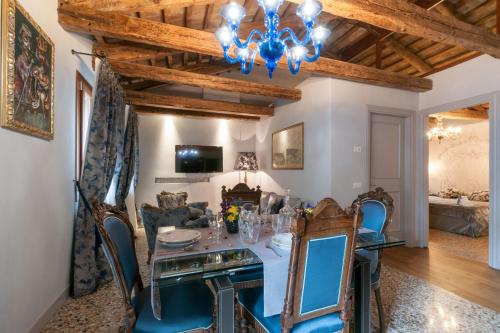 comedor con mesa, sillas y lámpara de araña en San Marco Luxury apartments Muneghe, en Venecia