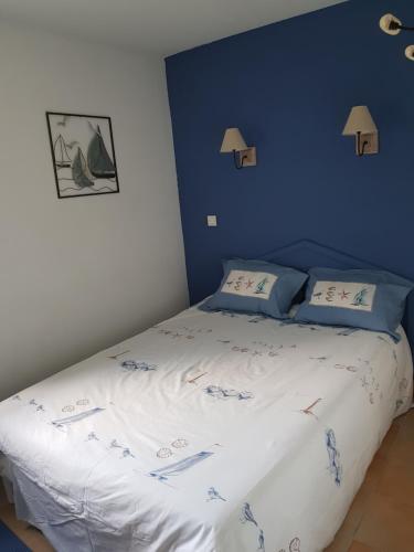 a bedroom with a bed with a blue wall at appartement domaine de Bordaberry Urrugne in Urrugne