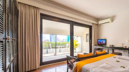 a hotel room with a bed and a large window at White Mansion 白色公馆 in Phnom Penh