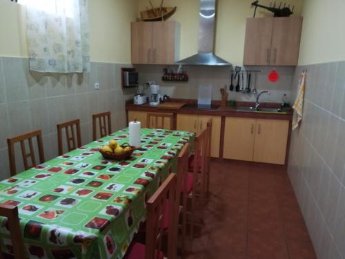 a kitchen with a table with a green table cloth at Albergue O Bordón in Cee