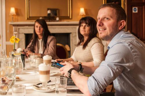 a man sitting at a table with two women at The Manor Hotel in Crickhowell