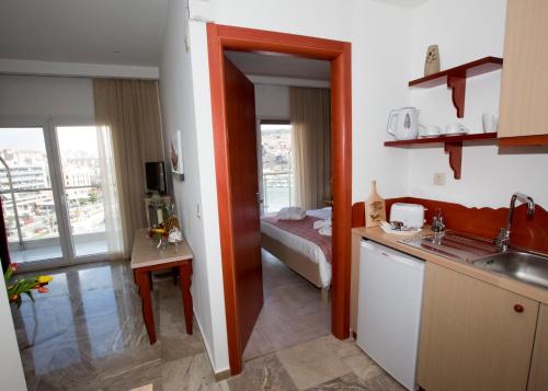 een kamer met een keuken en een slaapkamer met een bed bij Panorama Junior Suites in Kavala
