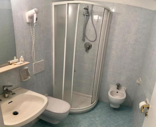 a bathroom with a shower and a toilet and a sink at Hotel La Gondola in Ischia