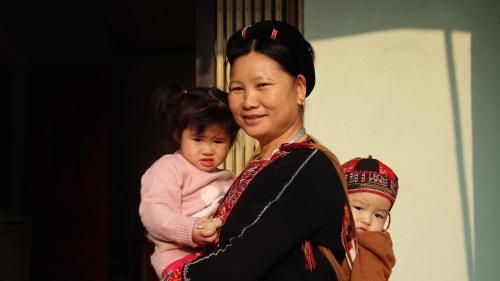 a woman holding a child and a baby at VuLinh Family -Homestay in Yên Bình