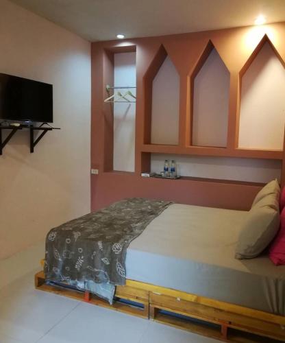 a bedroom with a bed and a flat screen tv at Nature Home in Phra Nakhon Si Ayutthaya