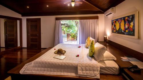 a bedroom with a large bed and a window at Sombra e Água Fresca Floresta in Pipa
