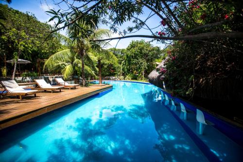 a swimming pool with lounge chairs and trees and a pool at Sombra e Água Fresca Floresta in Pipa