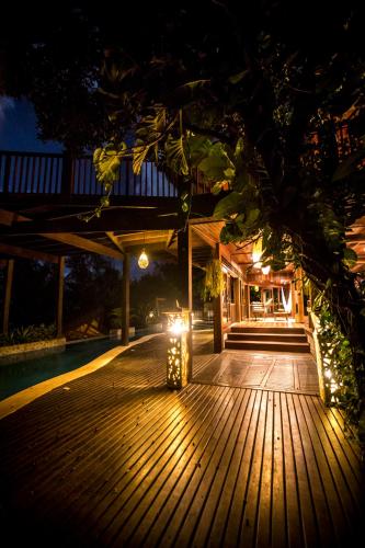 a wooden deck with lights on it at night at Sombra e Água Fresca Floresta in Pipa