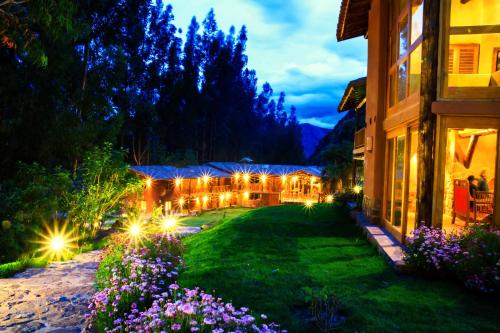 einen Garten in der Nacht mit Licht an einem Gebäude in der Unterkunft Sacred Dreams Lodge in Urubamba