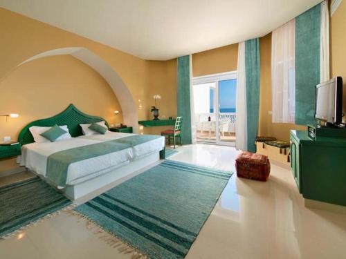 a bedroom with a large bed and a television at Villa Esmeralda in Lagos