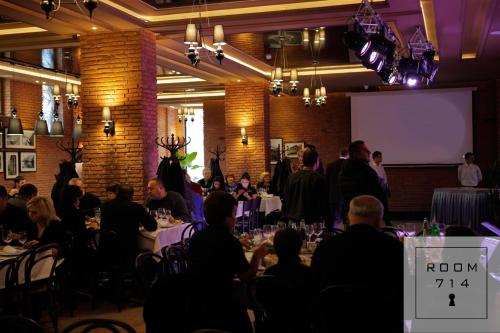 a group of people sitting at tables in a room at ORBI Palace Deluxe in Bakuriani