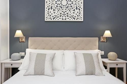 a bedroom with a white bed with two tables at St. Peter Home House in Rome