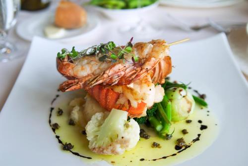 a plate of food with shrimp and vegetables on a table at Fraser Suites Riyadh in Riyadh