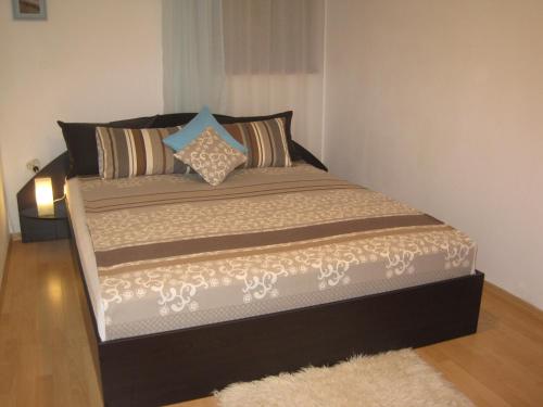 a large bed in a bedroom with a rug at Apartment Nadejda in Varna City