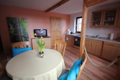 a kitchen with a table with a vase of flowers on it at Hainich-Zeit in Eigenrieden