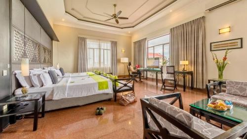 a bedroom with a large bed and a living room at White Mansion 白色公馆 in Phnom Penh