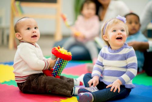 two babies sitting on the floor playing with a toy at Fraser Suites Riyadh in Riyadh
