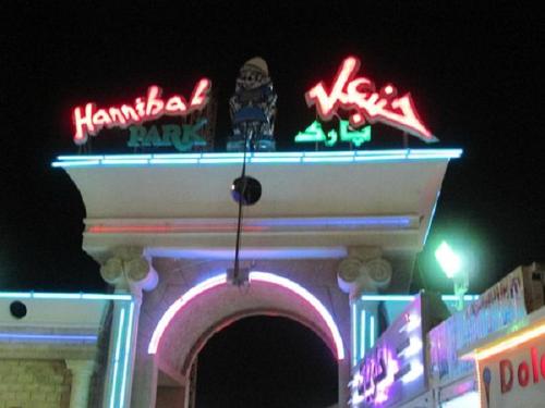 a building with neon signs on top of it at Apartment Essayadi Residence in Port El Kantaoui