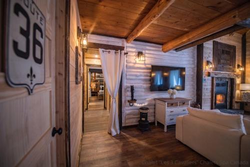 a living room with a couch and a table at Les 3 Cavaliers - Les Chalets Spa Canada in La Malbaie